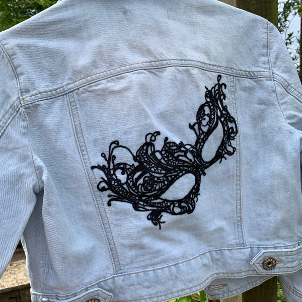 Denim jacket with drama mask embellishments